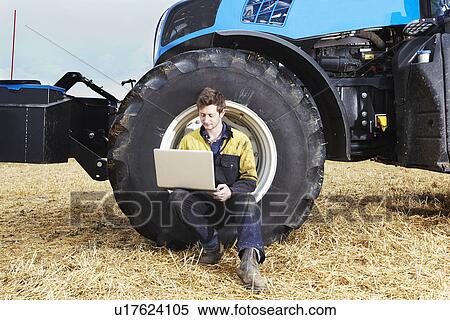 Stock Photography - Farmer using laptop in field. Fotosearch