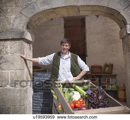Farmer wheeling cart of vegetables View Large Photo Image Stock Photo - Farmer wheeling cart of vegetables. Fotosearch