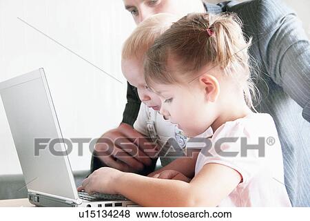 Father and children playing with laptop View Large Photo Image Stock Photo - Father and children playing with laptop. Fotosearch
