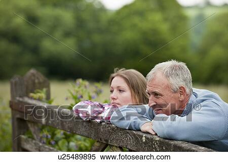 Stock Photography - Father and daughter on wooden fence. Fotosearch