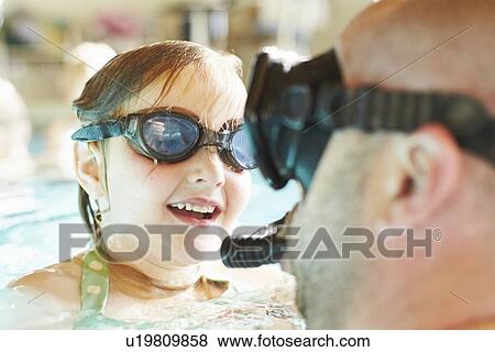 Stock Photo - Father and daughter swimming in pool. Fotosearch