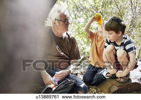 Stock Image - Father and his sons playing in the forest. Fotosearch