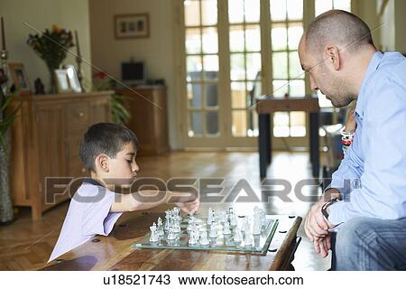 Father and son playing chess together View Large Photo Image Stock Image - Father and son playing chess together. Fotosearch