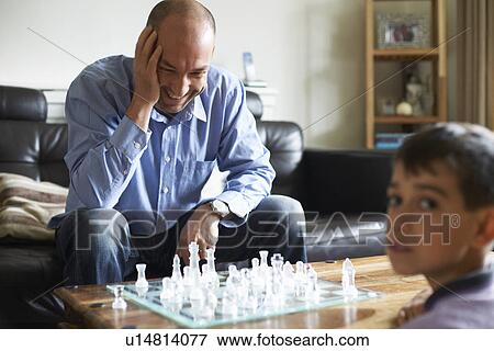 Stock Photo - Father and son playing chess together. Fotosearch