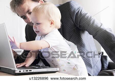 Father and toddler playing with laptop View Large Photo Image Stock Photograph - Father and toddler playing with laptop. Fotosearch