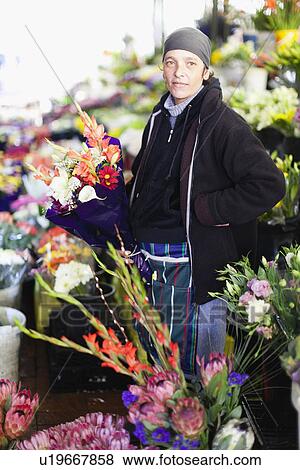 Stock Photo - Florist with bouquet of flowers at stand. Fotosearch