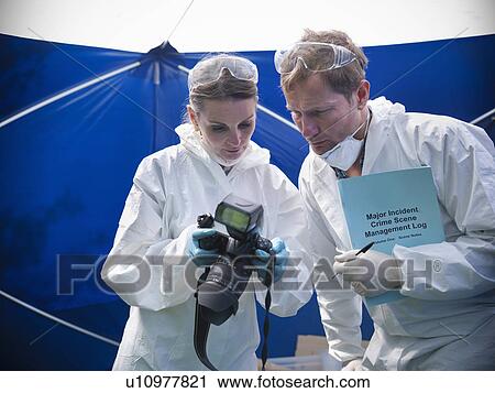 Stock Image - Forensic scientists at crime scene. Fotosearch