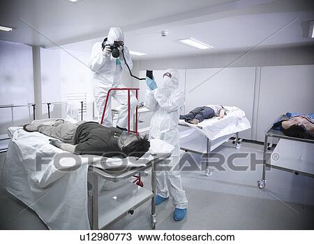 Stock Image - Forensic scientists with false corpse. Fotosearch