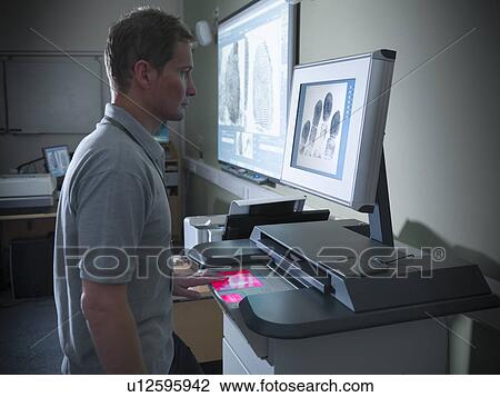 Stock Image - Forensic student taking fingerprints. Fotosearch