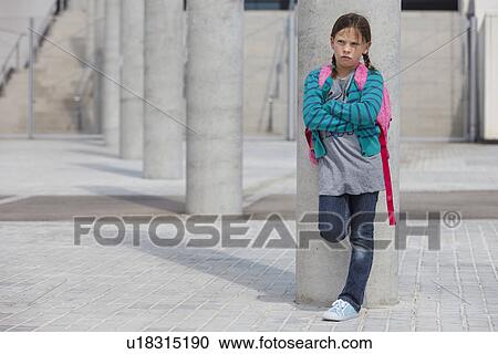 Frowning girl leaning against column View Large Photo Image Stock Image - Frowning girl leaning against column. Fotosearch