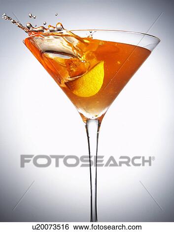 Stock Photograph - Fruit splashing in cocktail glass. Fotosearch