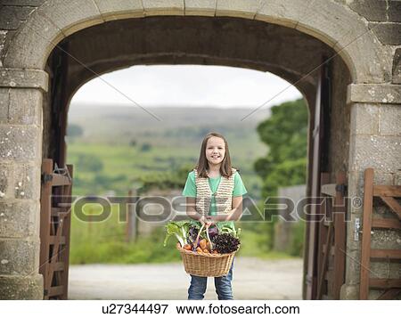 Girl carrying basket of vegetables View Large Photo Image Stock Photo - Girl carrying basket of vegetables. Fotosearch