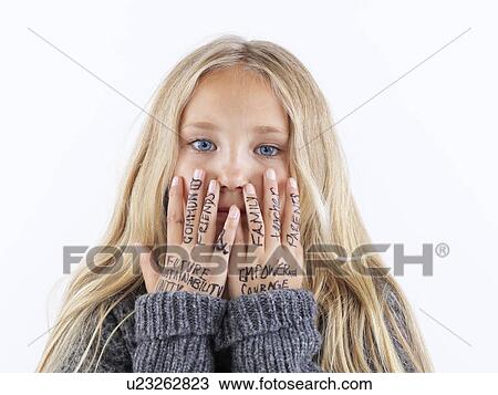 Stock Image - Girl covering face with writing on hands. Fotosearch