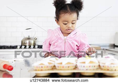 Girl decorating cupcakes in kitchen View Large Photo Image Picture - Girl decorating cupcakes in kitchen. Fotosearch