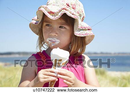 Girl eating ice cream on beach View Large Photo Image Stock Image - Girl eating ice cream on beach. Fotosearch