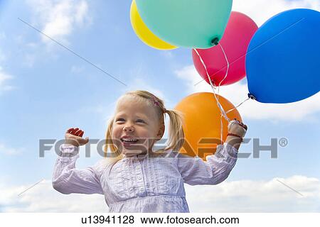 Girl holding bunch of balloons outdoors View Large Photo Image Stock Photo - Girl holding bunch of balloons outdoors. Fotosearch