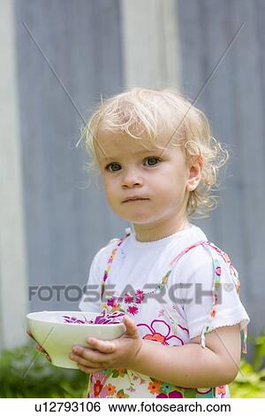 Girl holding flower in bowl outdoors View Large Photo Image Stock Photograph - Girl holding flower in bowl outdoors. Fotosearch