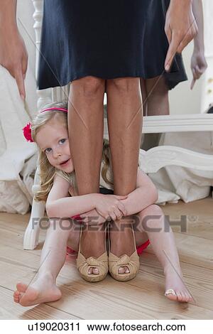 Stock Image - Girl hugging mothers ankles. Fotosearch