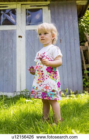 Girl picking flowers outdoors View Large Photo Image Stock Photograph - Girl picking flowers outdoors. Fotosearch