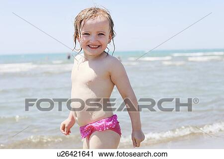 Girl playing in waves on beach View Large Photo Image Stock Image - Girl playing in waves on beach. Fotosearch