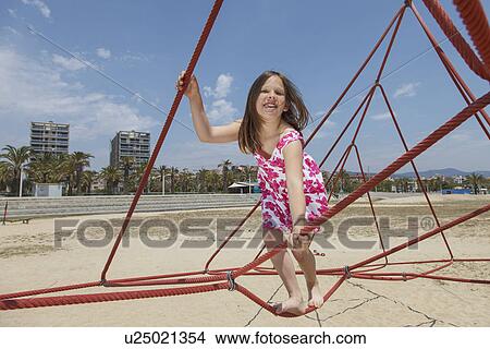 Picture - Girl playing on ropes on beach. Fotosearch