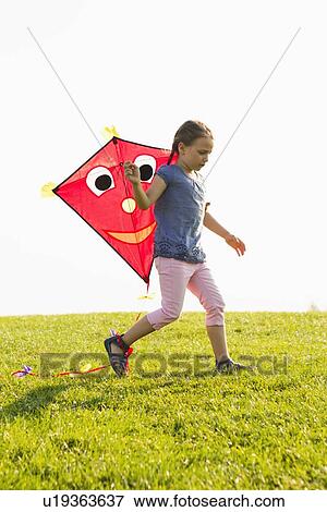 Girl playing with kite outdoors View Large Photo Image Stock Photo - Girl playing with kite outdoors. Fotosearch