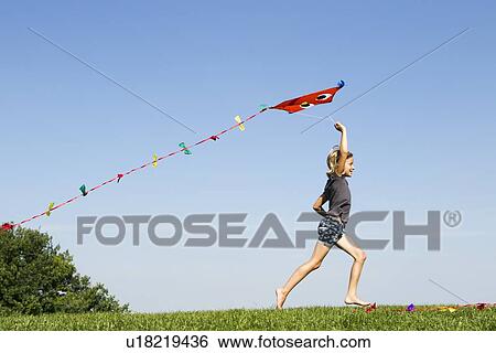 Girl playing with kite outdoors View Large Photo Image Stock Photograph - Girl playing with kite outdoors. Fotosearch