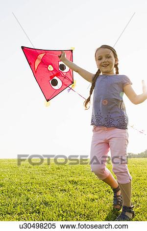 Girl playing with kite outdoors View Large Photo Image Stock Photography - Girl playing with kite outdoors. Fotosearch