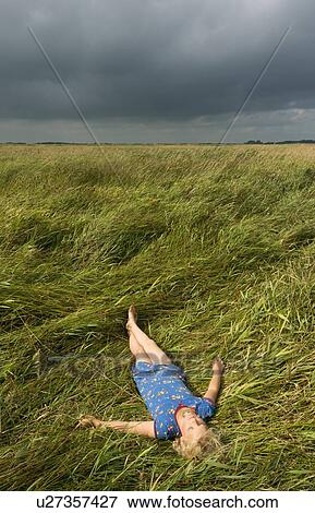 Girl relaxing in field of tall grass View Large Photo Image Stock Photo - Girl relaxing in field of tall grass. Fotosearch