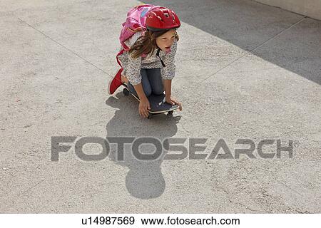 Stock Photo - Girl riding skateboard outdoors. Fotosearch