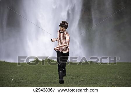 Stock Photo - Girl running in grassy field. Fotosearch