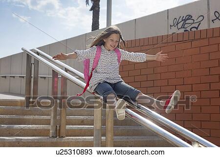 Girl sliding down banister on steps View Large Photo Image Stock Image - Girl sliding down banister on steps. Fotosearch