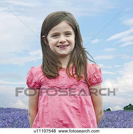 Girl standing in field of flowers View Large Photo Image Stock Photo - Girl standing in field of flowers. Fotosearch
