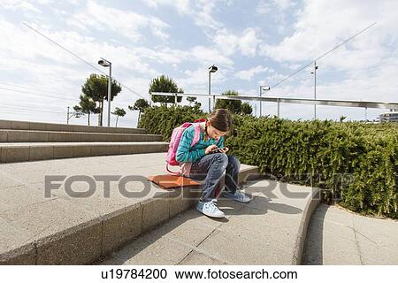Girl using cell phone on steps outdoors View Large Photo Image Stock Image - Girl using cell phone on steps outdoors. Fotosearch