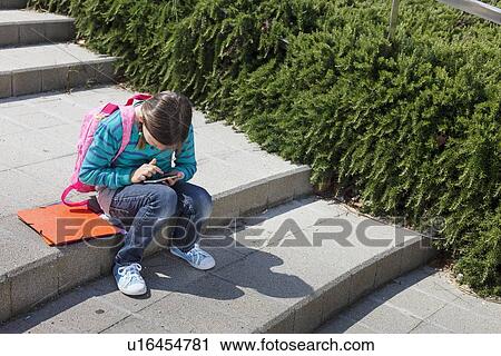 Stock Image - Girl using tablet computer outdoors. Fotosearch