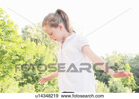 Stock Photo - Girl walking in meadow outdoors. Fotosearch