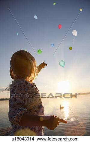 Girl watching balloons floating away View Large Photo Image Picture - Girl watching balloons floating away. Fotosearch