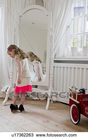 Stock Image - Girl wearing mothers high heels. Fotosearch