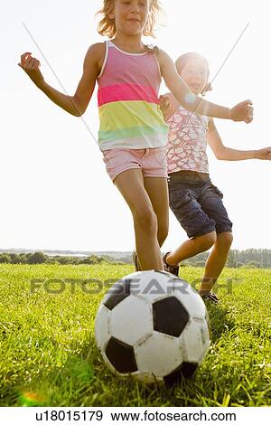 Girls playing soccer in field View Large Photo Image Stock Photo - Girls playing soccer in field. Fotosearch