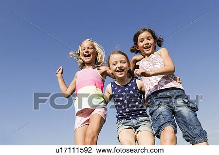 Stock Image - Girls playing together outdoors. Fotosearch