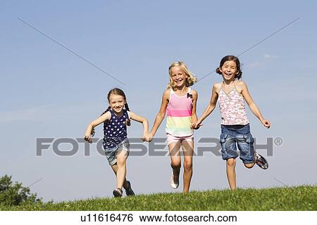 Girls running together in field View Large Photo Image Stock Photograph - Girls running together in field. Fotosearch