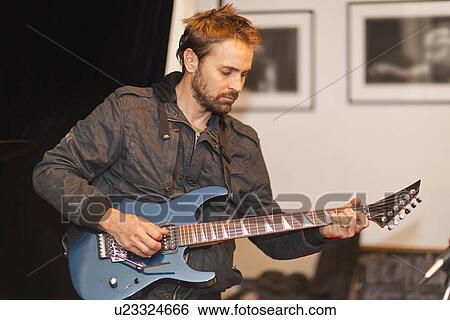 Guitar player practicing indoors View Large Photo Image Stock Photograph - Guitar player practicing indoors. Fotosearch