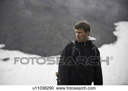 Stock Image - Hiker standing in snowy landscape. Fotosearch
