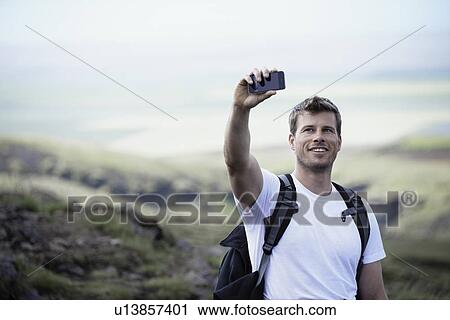 Hiker taking picture with cell phone View Large Photo Image Stock Image - Hiker taking picture with cell phone. Fotosearch