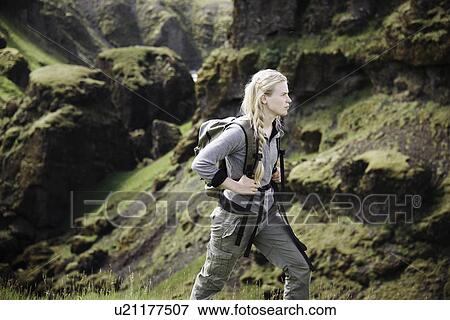 Stock Photo - Hiker wearing backpack on mountainside. Fotosearch