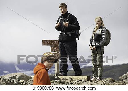 Hikers standing on rocky hilltop View Large Photo Image Stock Image - Hikers standing on rocky hilltop. Fotosearch