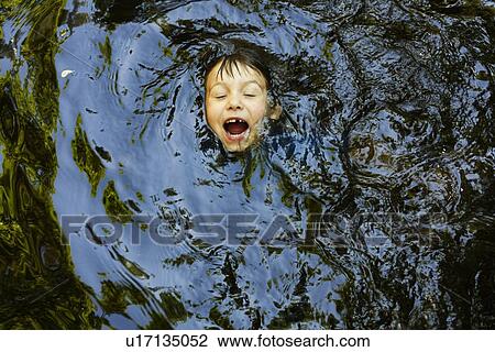 Laughing boy swimming in river View Large Photo Image Stock Image - Laughing boy swimming in river. Fotosearch