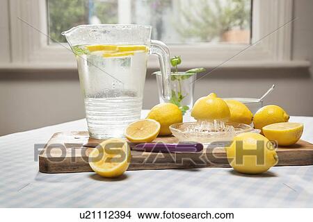 Picture - Lemons, juicer and pitcher of water. Fotosearch