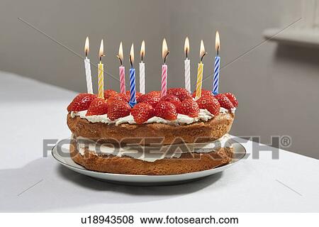 Lit candles on birthday cake View Large Photo Image Stock Photo - Lit candles on birthday cake. Fotosearch