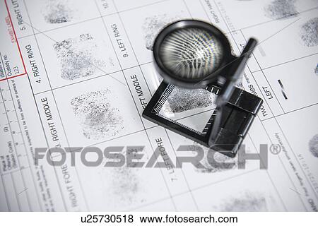 Stock Photo - Loupe over fingerprints on arrest form. Fotosearch